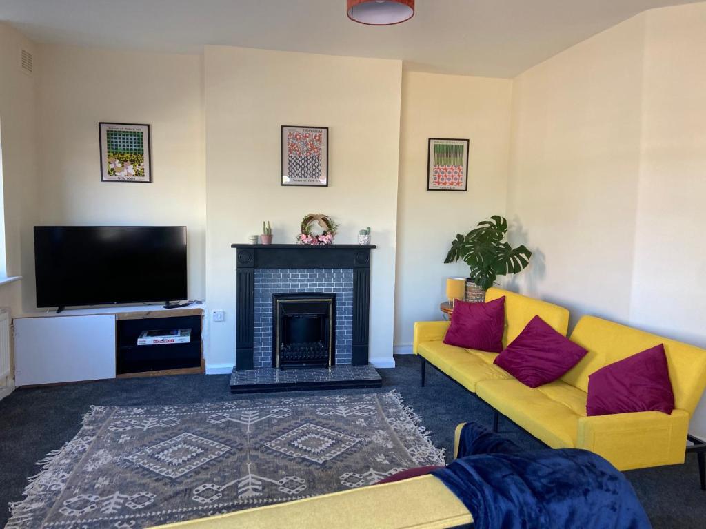 a living room with a fireplace and a tv at Town Centre House Sleeps 8 with parking in Stafford