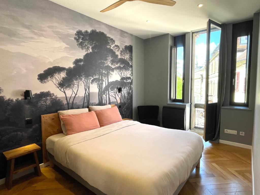 a bedroom with a bed with a painting on the wall at Le Cathedral View Colmar - Centre Historique - Parking privé gratuit in Colmar