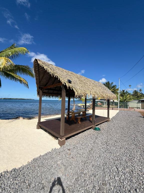 a straw hut on a beach with the ocean at Le TeRava - Beach House in Ataiti