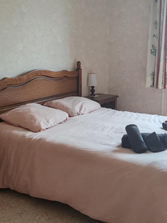 a bed with two pillows and two towels on it at Maison tout confort équipée Camargue in Saint-Gilles