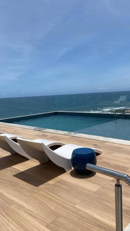 a swimming pool with a bench on the roof of a building at 808 Vista para o Mar in Salvador