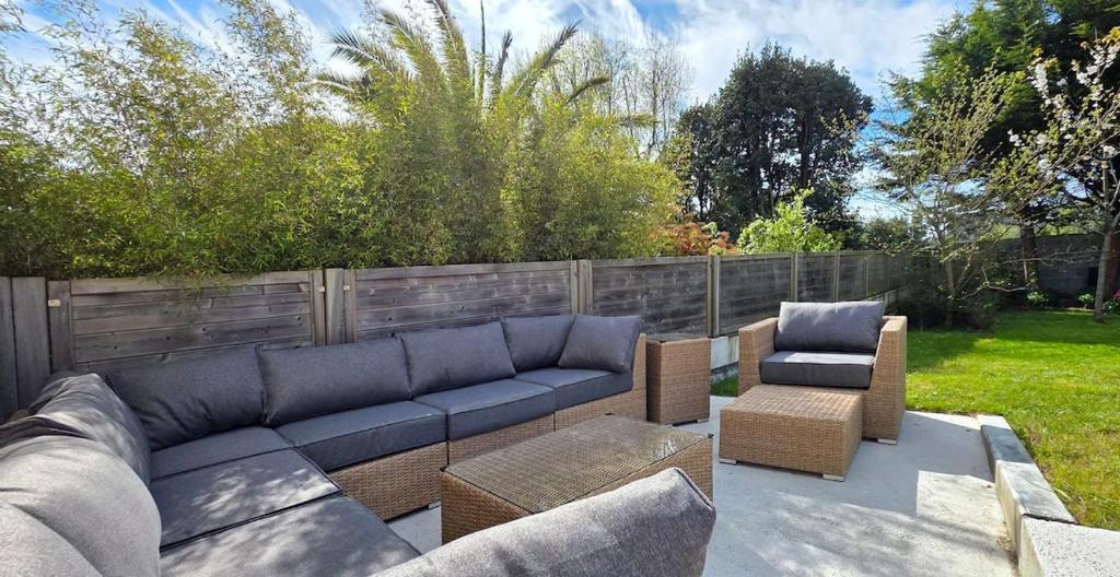 a blue couch and two chairs on a patio at Maison Ty Cloclo in Quiberon