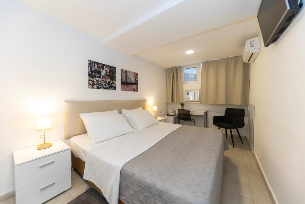 a bedroom with a white bed and a desk at CentRooms Kovac1 in Zadar