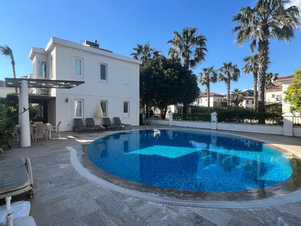 a large swimming pool in front of a white house at Dalyan Villa in Dalyan