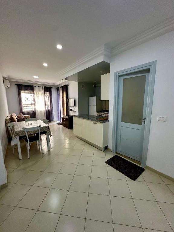 a kitchen and dining room with a table and a door at Appartement le jasmin in Hammamet