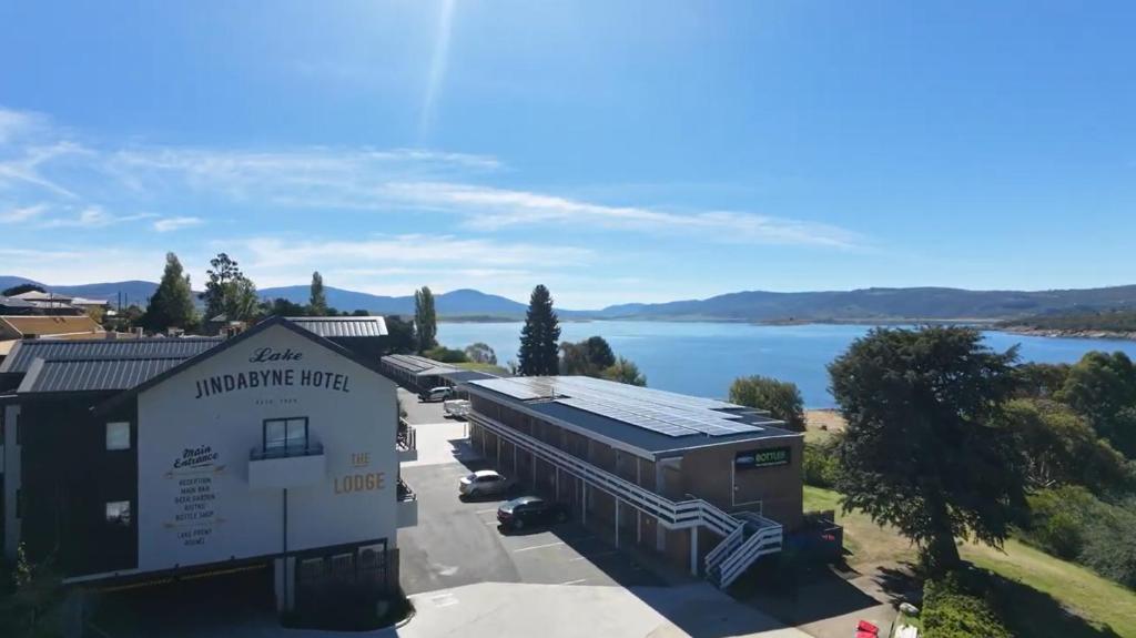 an aerial view of a building with a lake in the background at Lake Jindabyne Hotel in Jindabyne
