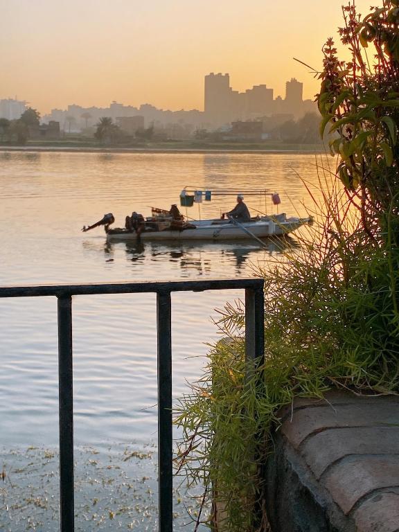 a man in a boat on the water at sunset at Nile residence in Al Kawāmil Qiblī