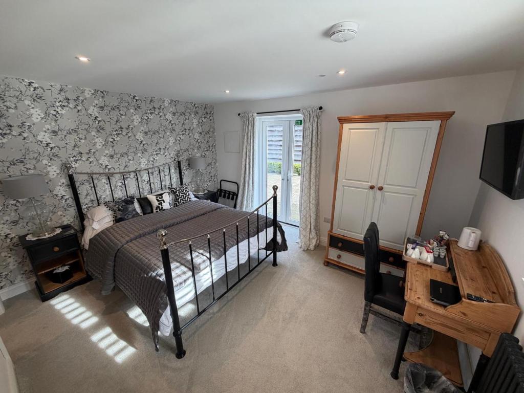 a bedroom with a bed and a desk and a window at Abbey Green Farm in Wem