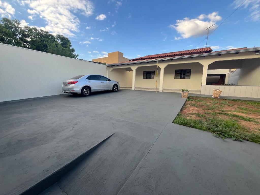 a car parked in a parking lot in front of a building at Casa aconchegante com 2 quartos, próximo ao Centro, UFU, Center Shopping e Convention, Hospitais e Aeroporto in Uberlândia