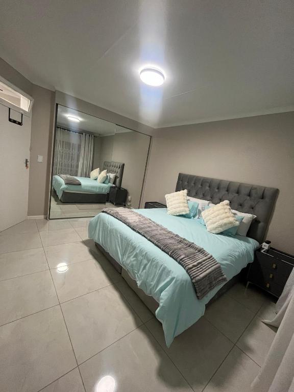 a bedroom with a large bed and a mirror at The Kempton Star in Kempton Park