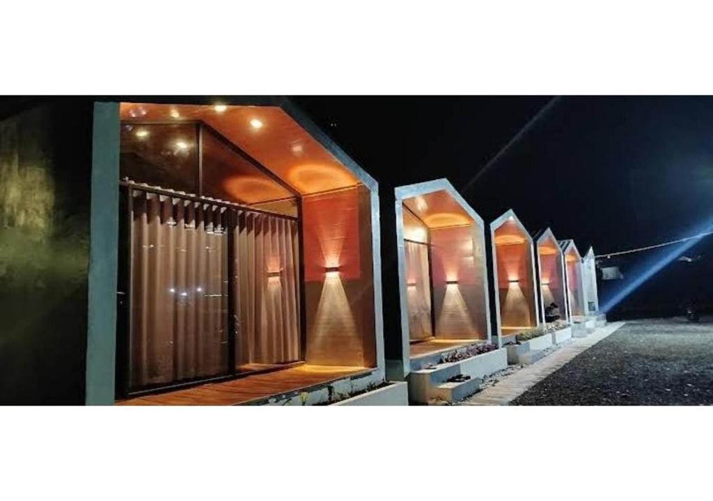 a row of metal stalls in a building at night at D'BAGOES Luxury Cabin in Sarangan