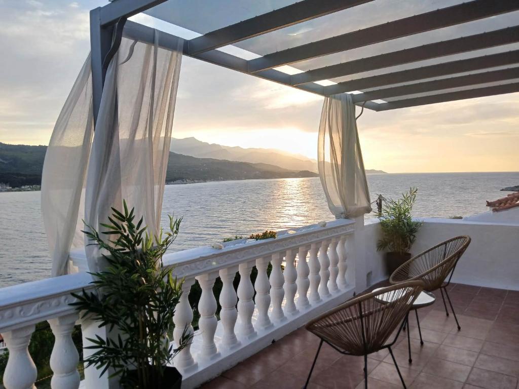 a balcony with chairs and a view of the water at Samos Blue Haven in Samos