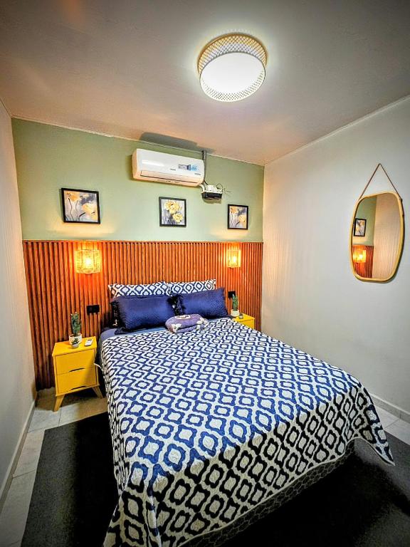 a bedroom with a bed with a blue and white comforter at Quincho's Place in Santa Ana