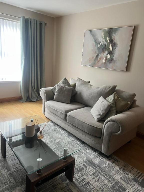 a living room with a couch and a glass table at The Clady Home in Clady