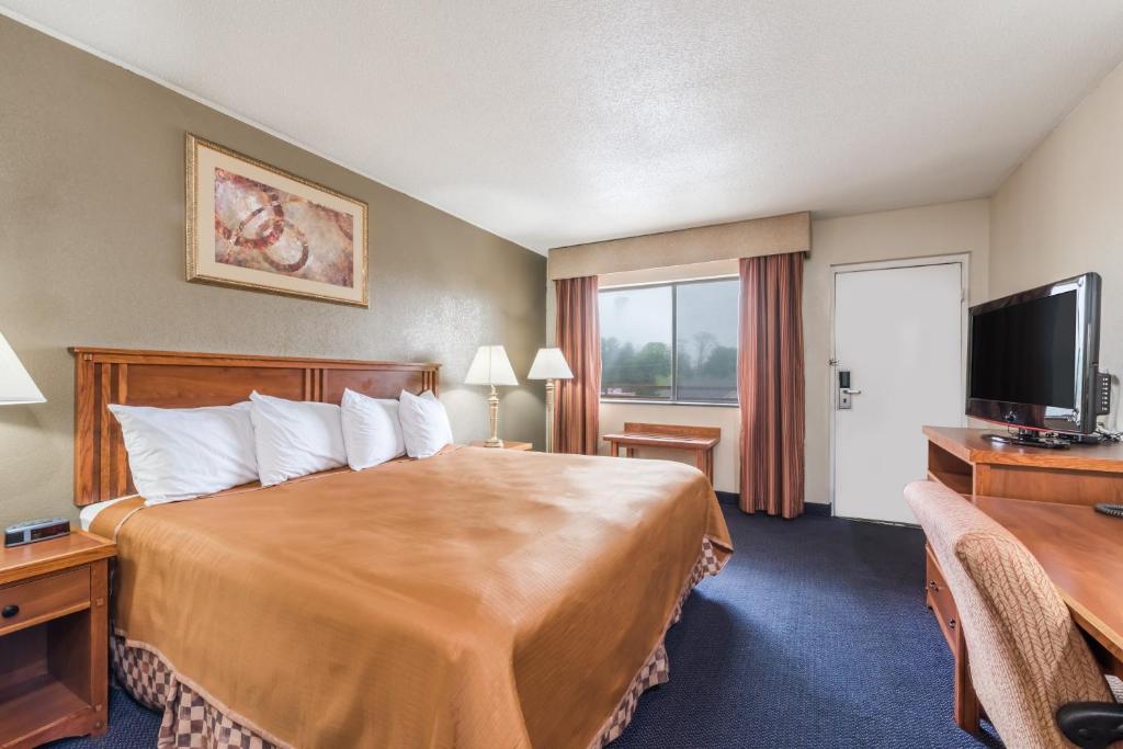 a hotel room with a large bed and a flat screen tv at Red Carpet Inn Lancaster in Lancaster