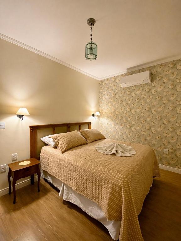 a bedroom with a large bed and a table at Casa Julieta in Serra Negra