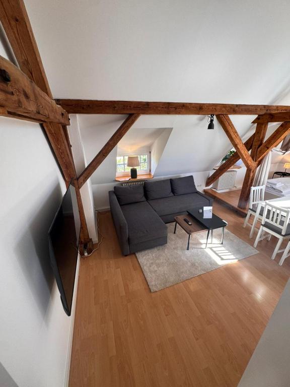 an attic living room with a couch and a tv at Bavaria Home Kitchen Parks No 5 in Geisenfeld