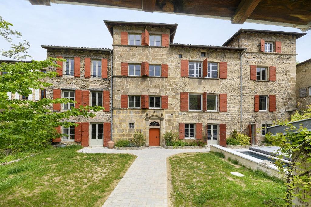 an old stone house with a courtyard at Chateau- La Providence in Satillieu