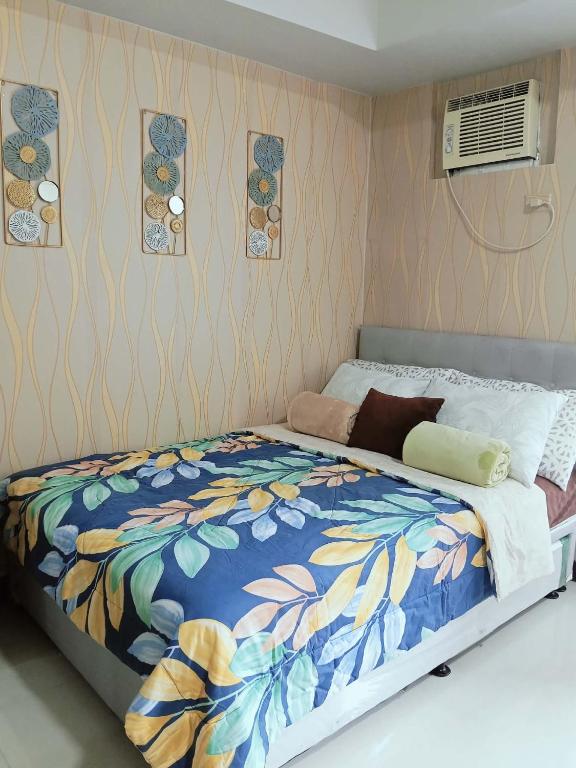 a bedroom with a bed with a colorful blanket at Manhattan Heights TowerD-Unit5 Viv's room Studio type in Manila
