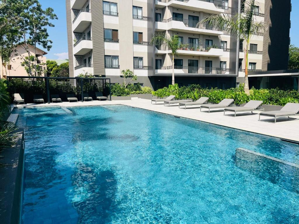 a swimming pool in front of a building at AccraAura-Airport Residential in Accra