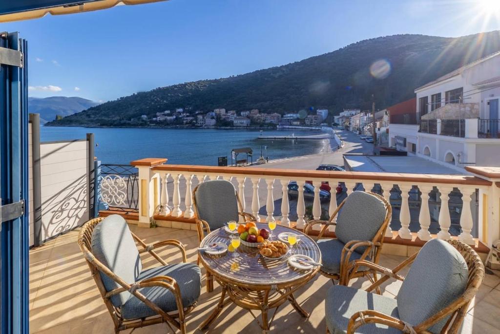a balcony with a table and chairs and a view of the water at VERANDA MARE in Agia Effimia