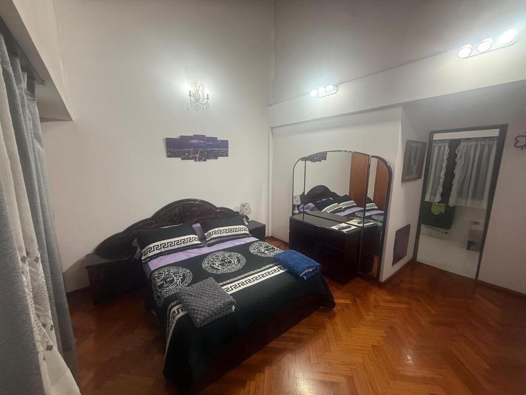 a bedroom with a bed and a large mirror at Hostel amplio y confortable in Munro