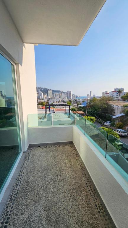 a balcony of a building with a view of the city at Comfortable apartment with pool, close to the beach in Acapulco