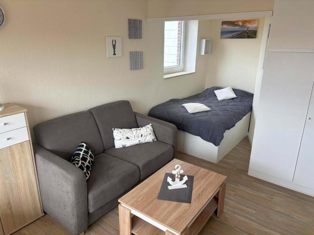 a living room with a couch and a bed at Tief 12 Seeigel 31 in Wangerland