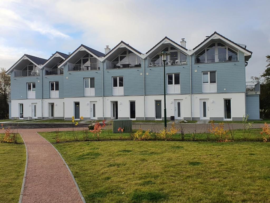 a large blue building with a lawn in front of it at Meerblick 43 in Wangerland