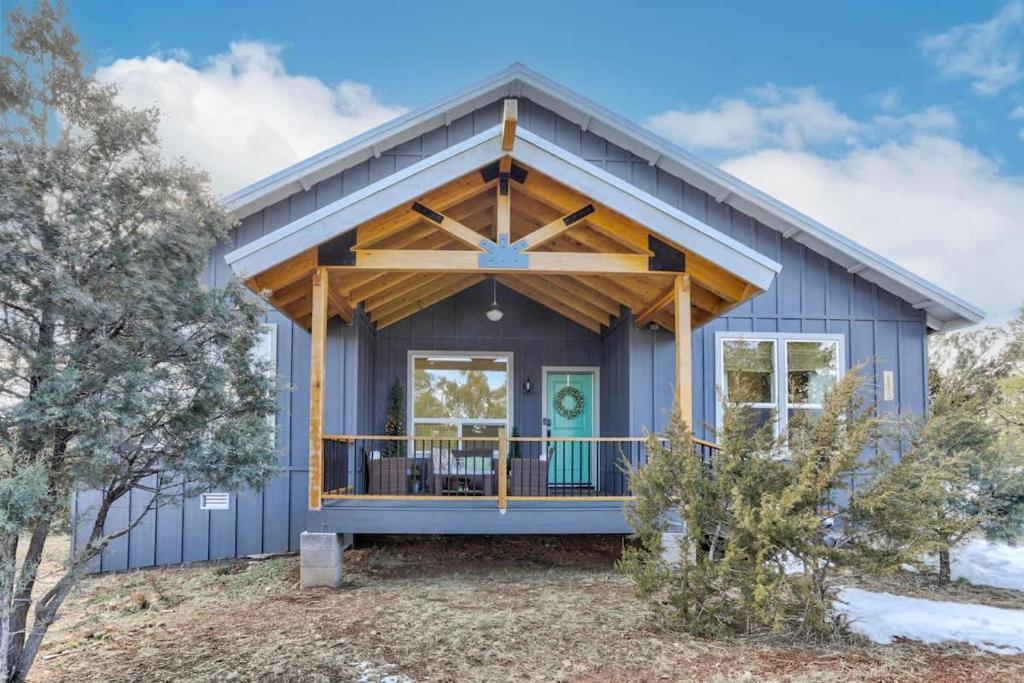 a blue house with a large front porch at Blue Betty Acre in Overgaard