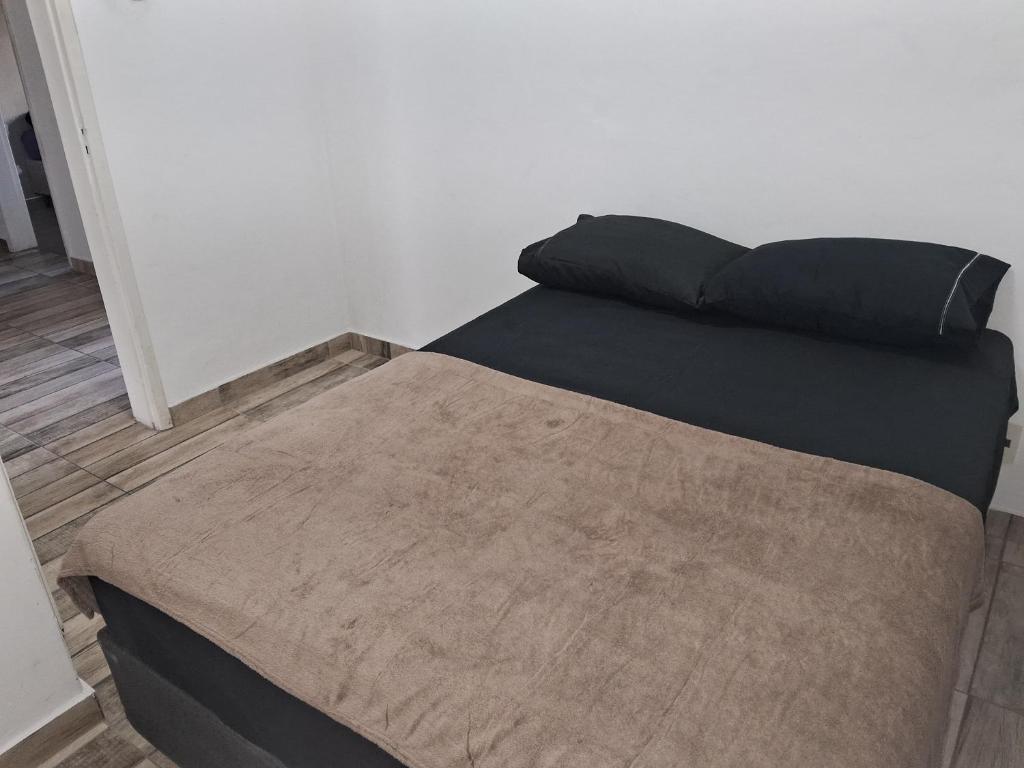 a bed in a room with a pillow on it at Pousada Paula Lima II in Juiz de Fora