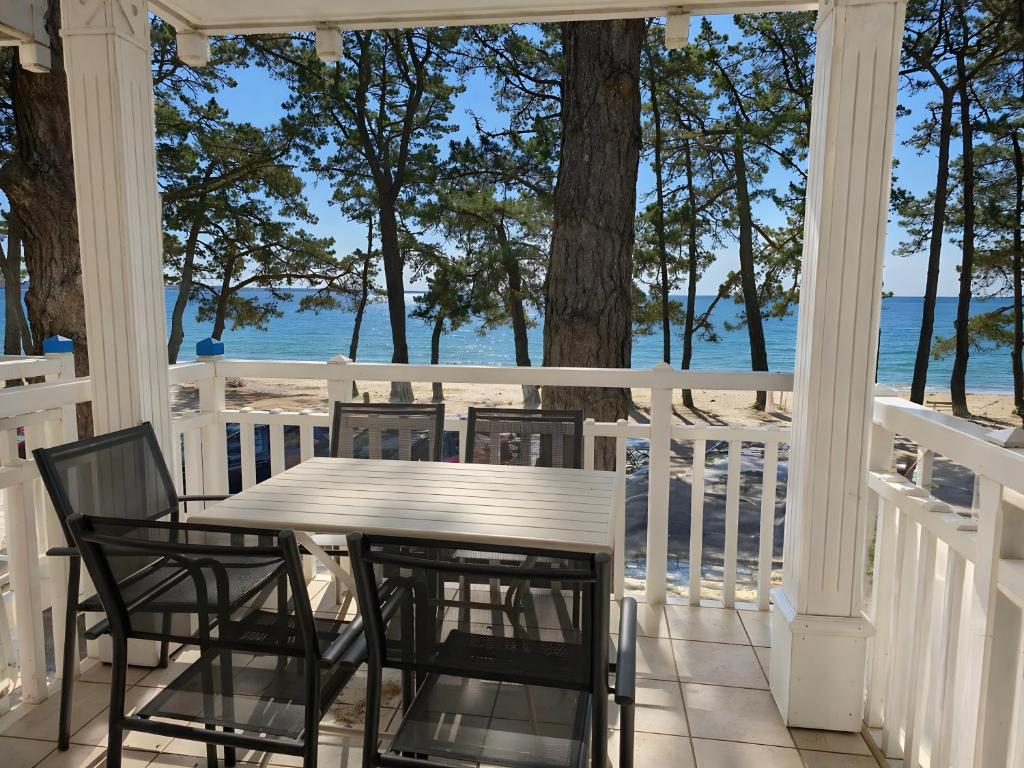 a porch with a table and chairs and the ocean at La Cabine in Fouesnant