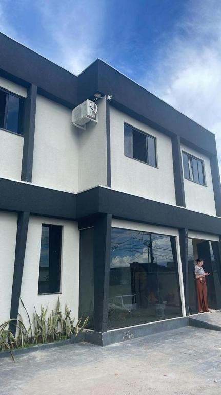 a person standing in front of a building at Apartamento Salinas in Cacoal