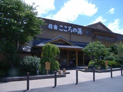 un edificio con una señal delante de él en Ibusuki Kokoronoyado en Ibusuki