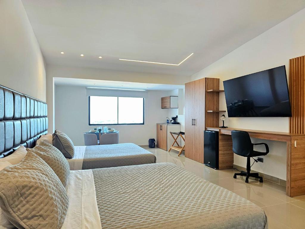 a hotel room with two beds and a flat screen tv at Hotel Casa Cristales in Cali