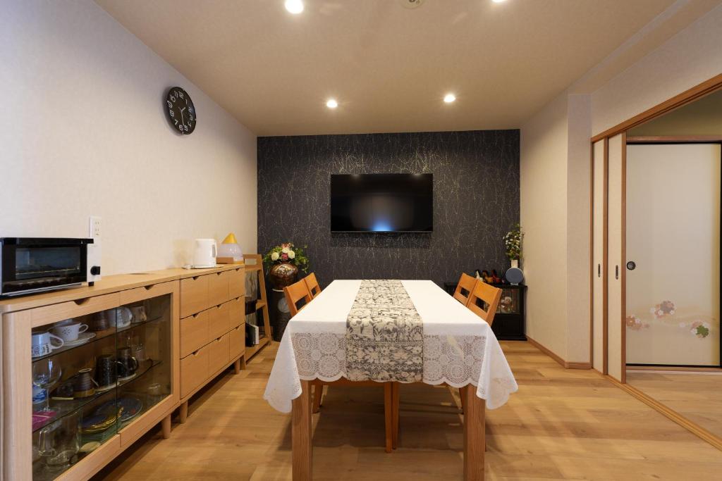 a dining room with a table and a tv at 嵐lan in Kyoto
