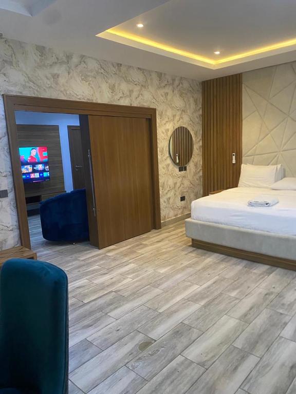 a bedroom with a bed and a television in it at Triple 9 Apartments,Pool & Spa in Abuja