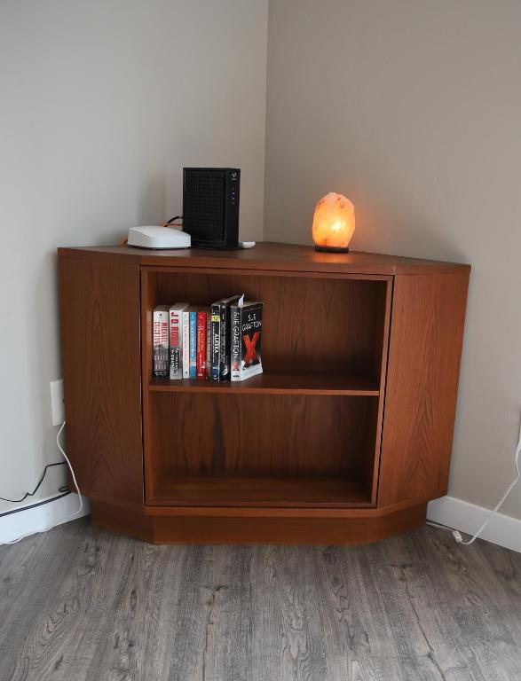 a wooden book shelf with a laptop and books at Retreat on First Street in Prescott