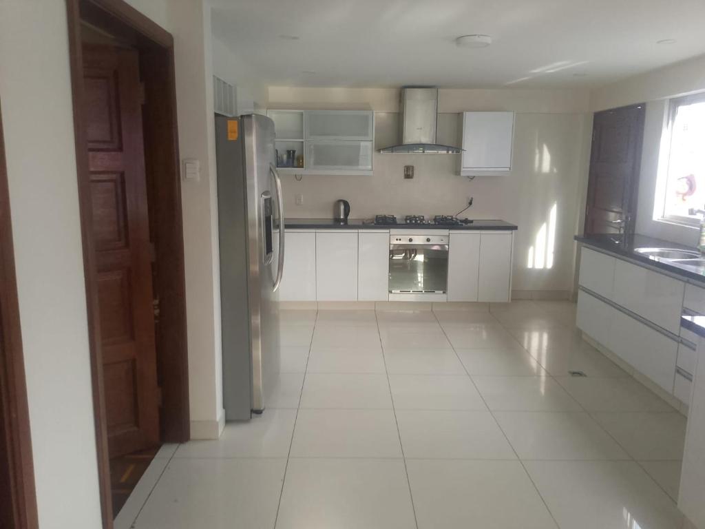 a kitchen with white appliances and a white tile floor at Precioso Monoambiente Independiente in La Paz