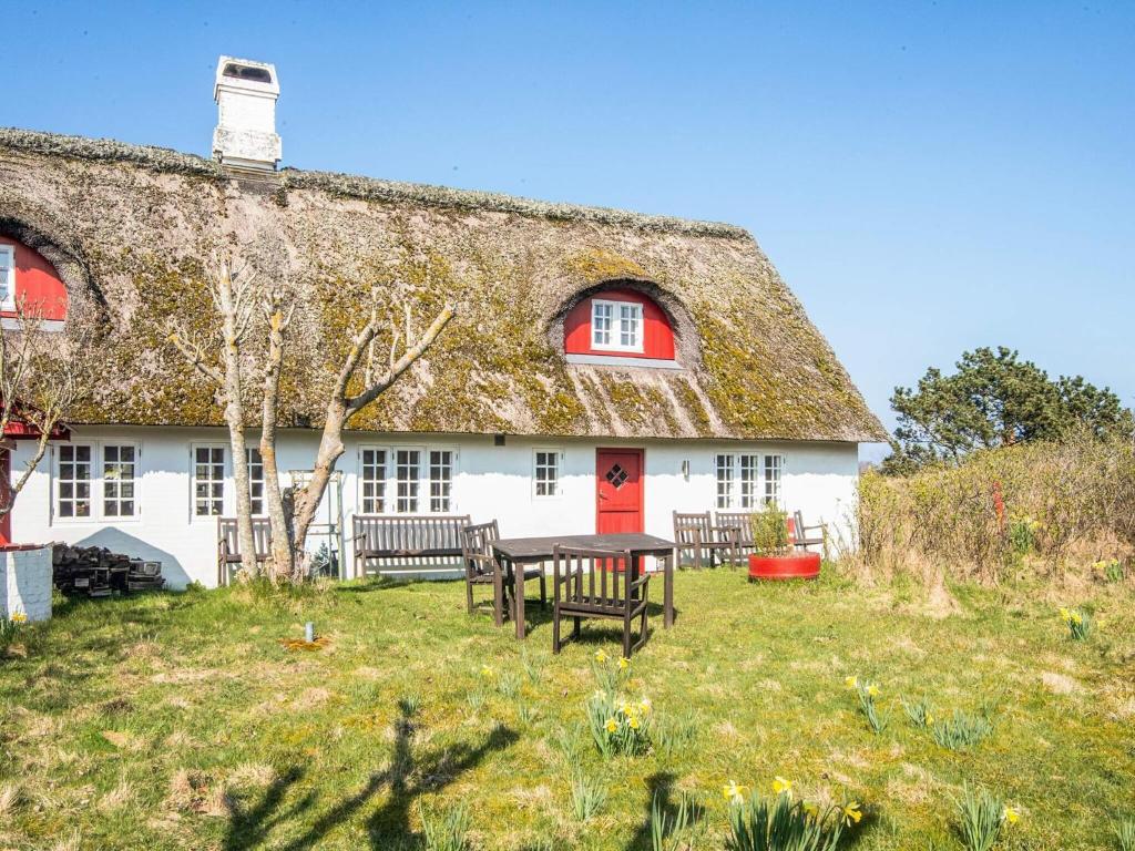 a house with a table and chairs in front of it at Home with Spa and Fireplace in Fanø