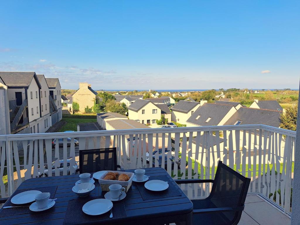 a table with a bowl of food on a balcony at Sea View Family Stay in Plouarzel in Plouarzel