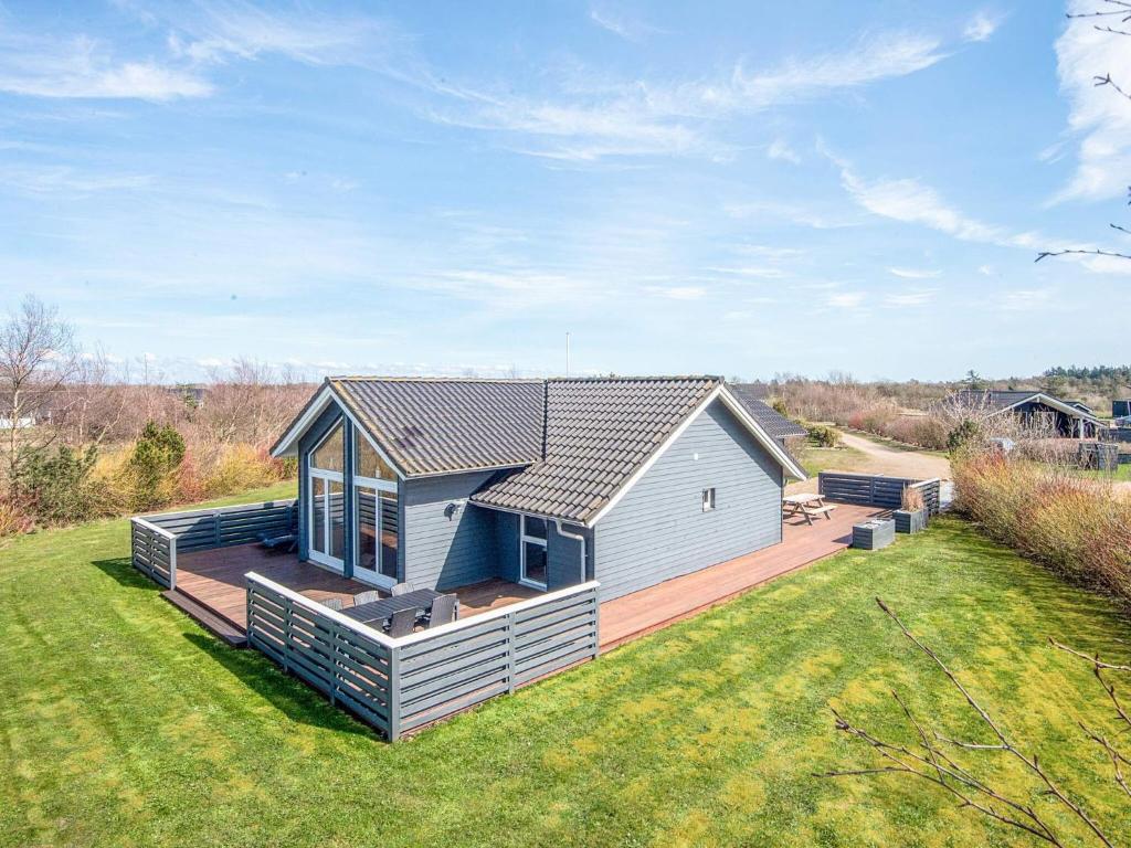 a small house with a large deck in a yard at 8 person holiday home in Tarm in Tarm