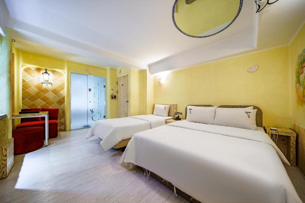 a hotel room with three beds and a mirror at Amant Hotel in Goyang