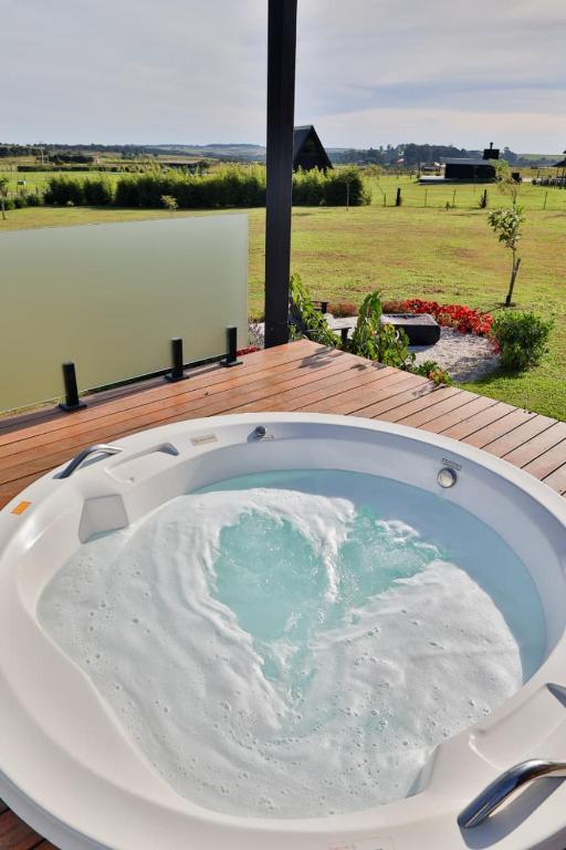 a bath tub sitting on top of a wooden deck at Cabanas Purunã Ipê-Amarelo in Balsa Nova