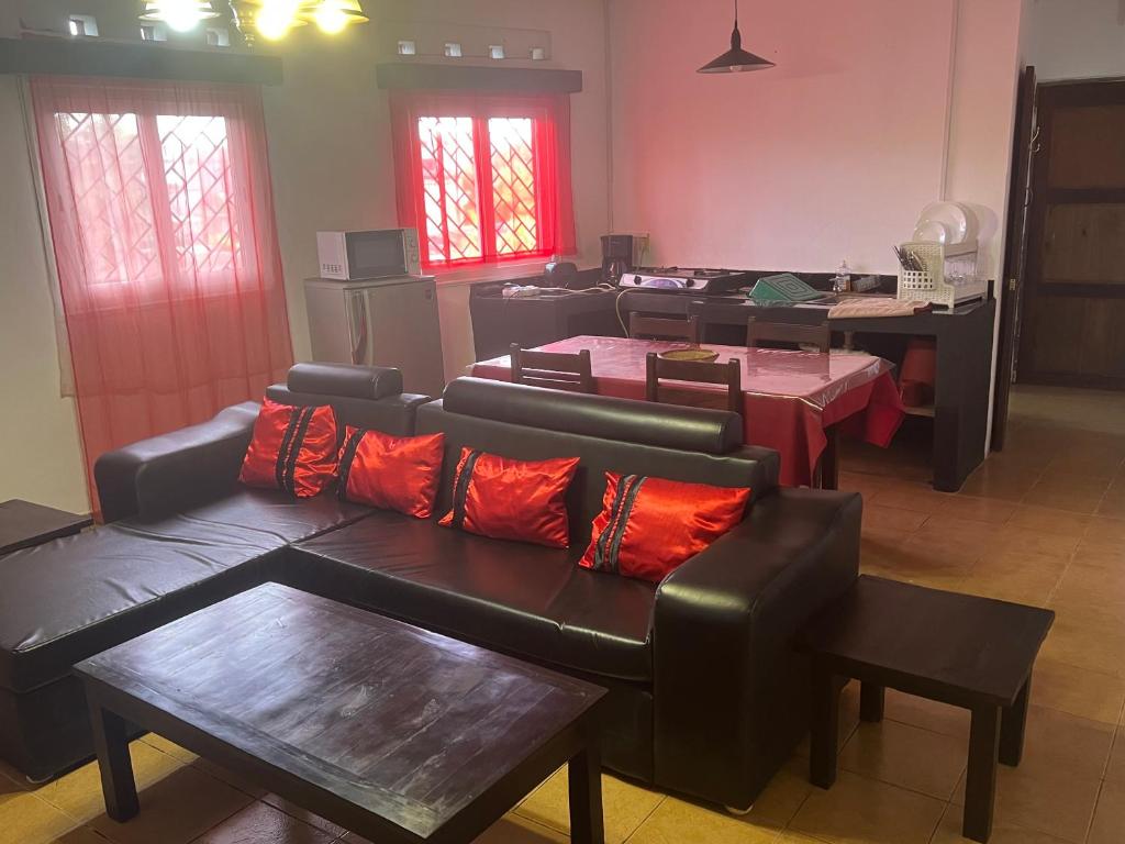 a living room with couches and a table and windows at Villa CALI Napa in Sambava