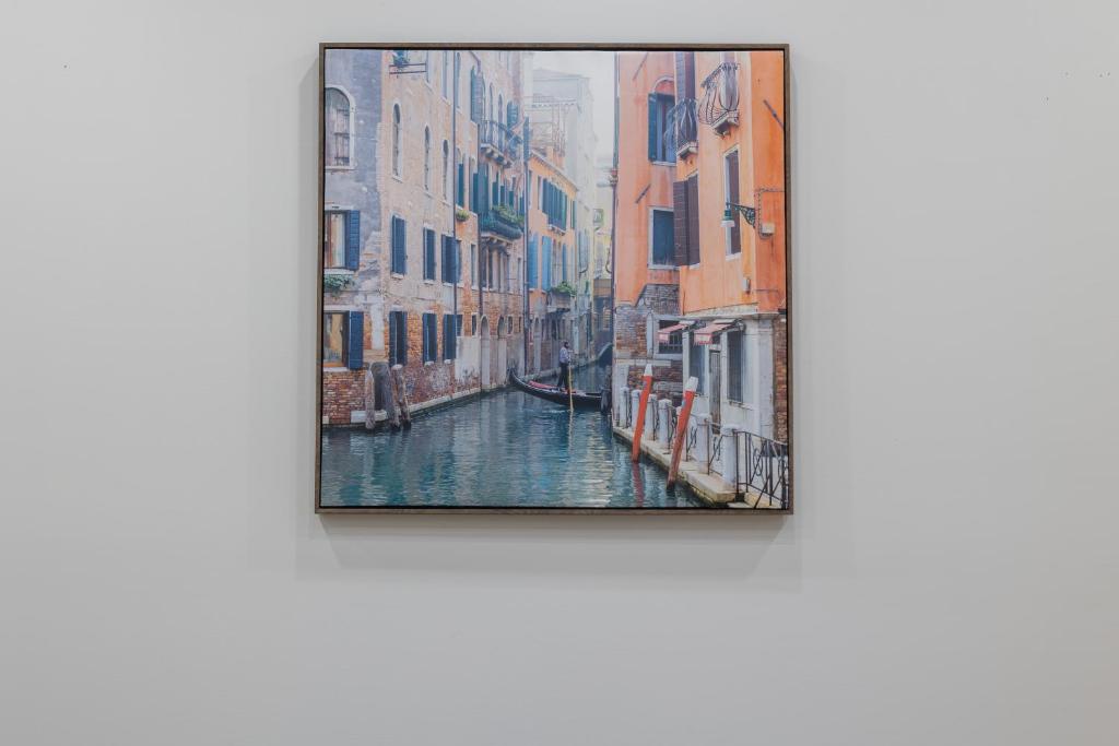 a painting of a canal with buildings at Cozy Home by Niagara Falls in Thorold