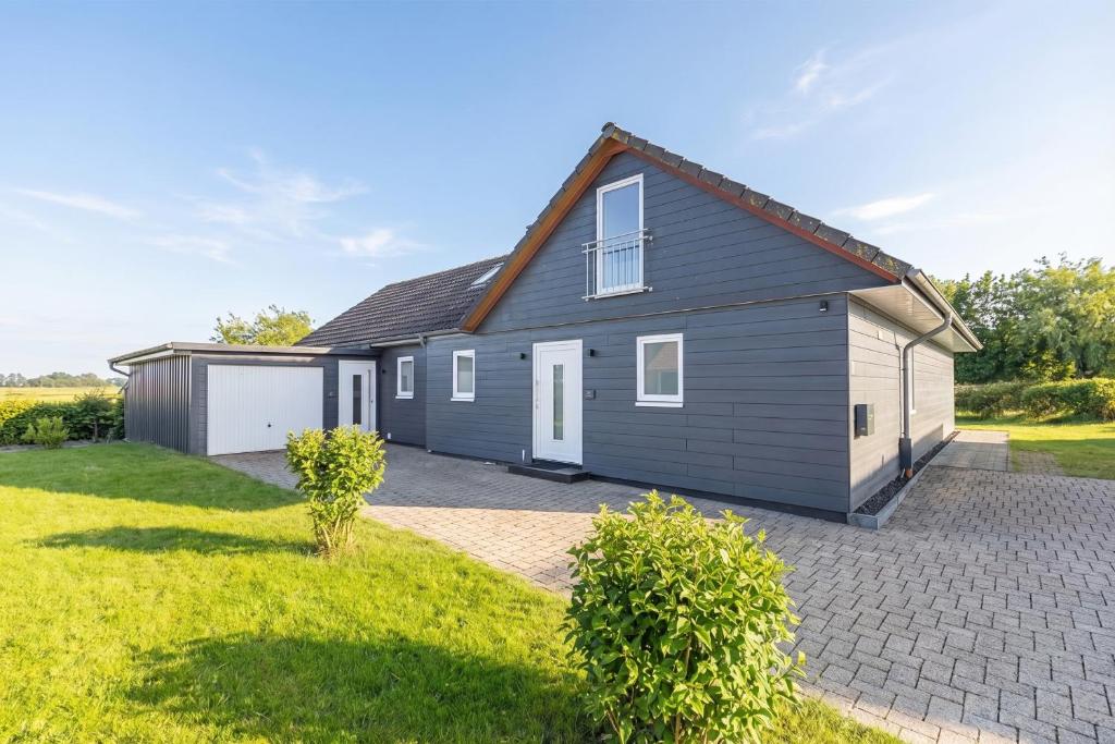 a house with a garage in a yard at Cottage am Deich Whg Marlene in Uelvesbüll