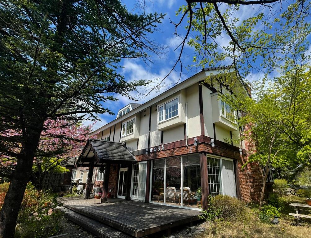 a large house with a porch and trees at 森のうた Morinouta Forest Stay in Nikko in Nikko