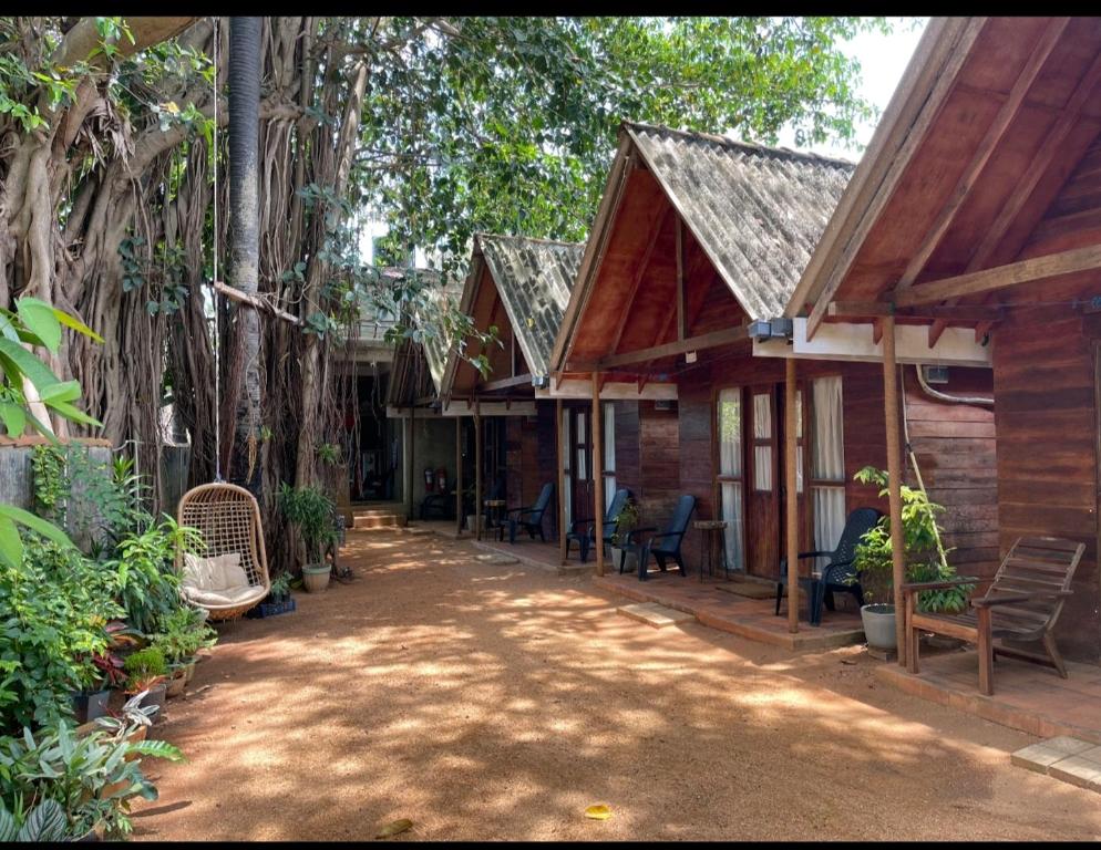 a house with a porch with chairs and trees at Cool Banyan Cabana in Trincomalee