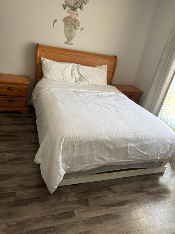 a bed with a white comforter and pillows at Cozy room in Kitchener